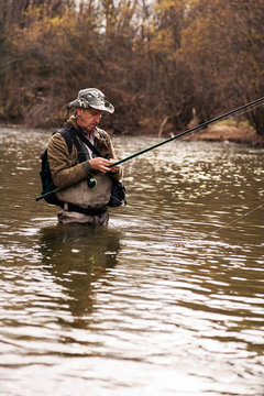 Fisherman standing in river when fishing for trout