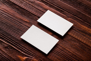 Closeup mockup of two blank horizontal business cards at brown w