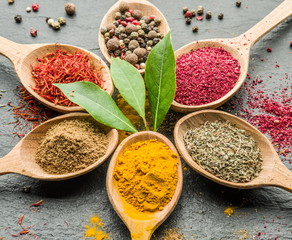 Assortment of colorful spices in the wooden spoons.