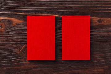 Closeup mockup of two red vertical business cards at brown woode