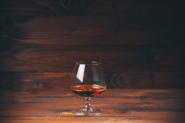 Glass of brandy or cognac on the wooden table.