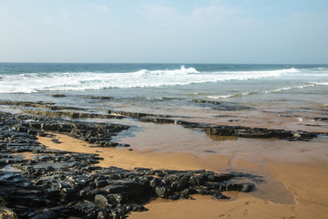 Rocks on Sea shore Against Ocean and Blue Skyline