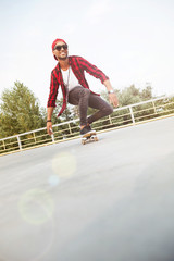 Young dark skinned guy skateboarding