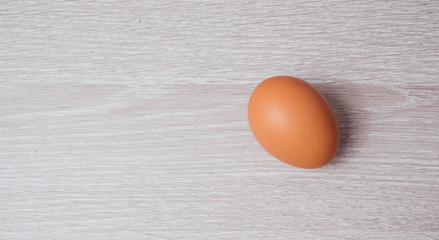 Chicken egg on wooden table/ floor background