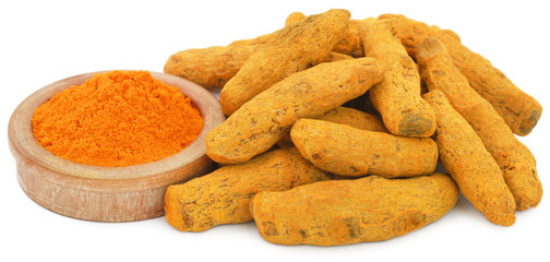 Whole and ground turmeric in bowl