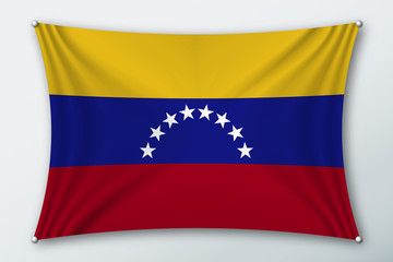 Venezuela national flag. Symbol of the country on a stretched fabric with waves attached with pins. Realistic vector illustration.