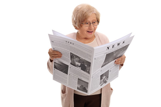 Surprised elderly woman reading a newspaper