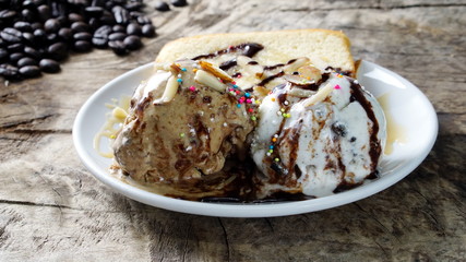 Ice cream and butter cake put on a wood table with dark roasting coffee beans.