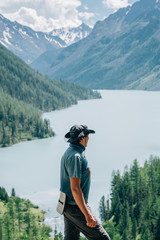 Traveler man relaxing outdoor with mountains and lake on background.