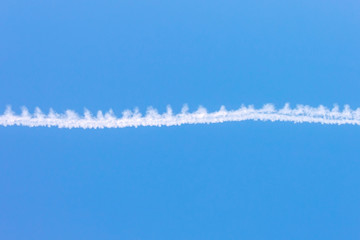 White airplane trace on blue sky
