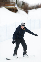 Fototapeta na wymiar Portrait of young man in sportswear with snowboard