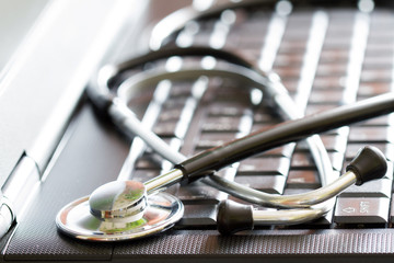 Stethoscope on black laptop computer medical technology concept with blurred background
