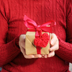 congratulations with love/ gift in festive packaging with heart symbol associated hands 
