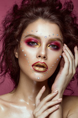 Beautiful girl with bright fashion make-up, and heart from crystals on the face. Valentine's Day. Photos shot in studio