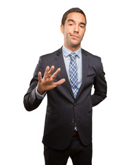 Serious young businessman doing a keep calm gesture