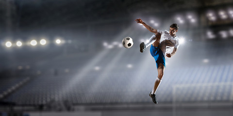 Fototapeta na wymiar Soccer player at sport arena . Mixed media