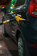 Car refueling on a petrol station in winter at night