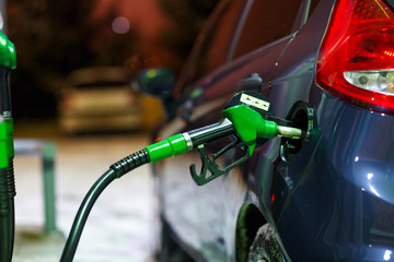 Car refueling on a petrol station in winter at night