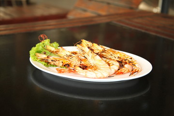 Grilled prawn ready to serve on white dish.