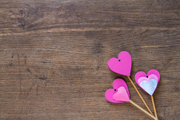 Pink hearts on the wooden background