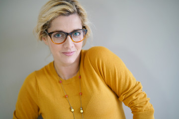 Beautiful blond woman with eyeglasses and yellow shirt, isolated