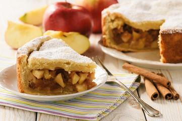 Apple pie and cup of tea on white wooden background.