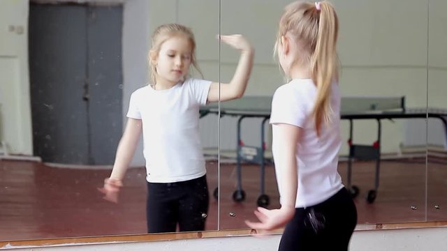 Little girl fun dancing training exercise in front of mirror
