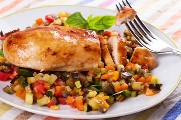 Chicken breast with sauteed vegetables: eggplant, carrot, zucchini, squash and tomatoes