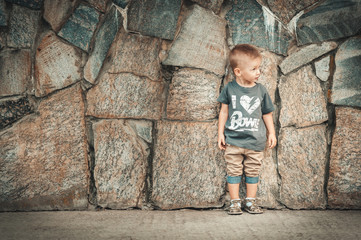 Little baby boy in fashionable clothing have fun outdoors