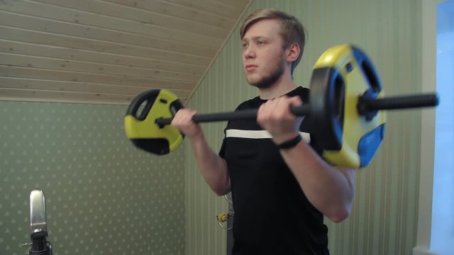 Young man working out his hands lifting dumbels and exercise his biceps