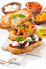 bruschettas with tomatoes and mozzarella on wooden board