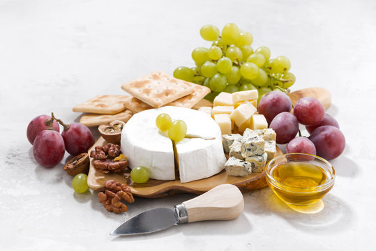 camembert, grapes and crackers on a white table