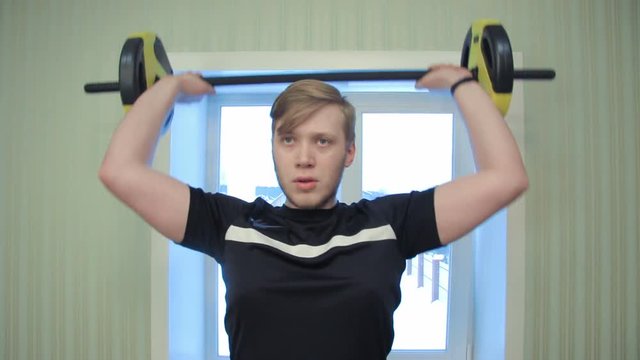 Young man working out his hands lifting dumbels and exercise his biceps