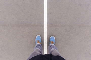 Two sides on asphalt ground, feet and shoes on floor