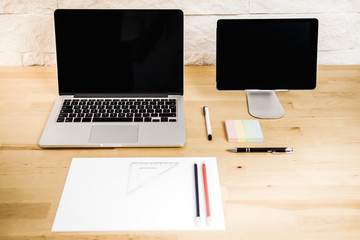 Fototapeta premium view on a wooden desk with a computer tablet and paper