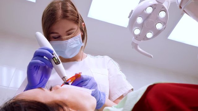 Installation of veneers, crowns, using special wireless led photopolymerization lamp with orange protection