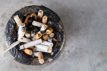Overhead view of dirty cigarette butts in ash tray