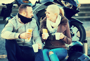 Fototapeta na wymiar Cheerful young couple having picnic with coffee