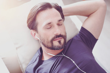 Pleasant bearded man resting at home