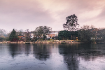Fototapeta na wymiar British Houses Reflected on Surface of Frozen Pond