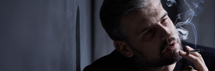 Obraz premium Sad man smoking cigarette