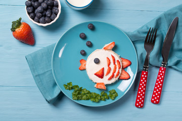 Funny toast in a shape of fish, sandwich with cream cheese and berries, food for kids idea, top view