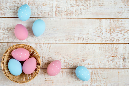 Easter eggs over white wooden vintage table - top view, copy space