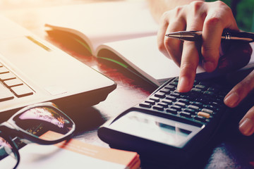 Close up woman doing finance at home office with calculate expen