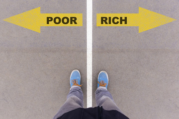 Poor vs Rich text arrows on asphalt ground, feet and shoes on fl