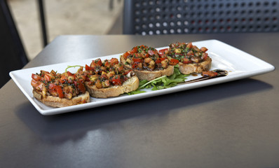 Maltese food in blurry background, Real italian brucheta,sicilian food, fresh snack in Sicily, italian kitchen,sicilian kitchen, maltese Appetizer Bruschetta with  tomatoes, tuna, garlic and herbs
