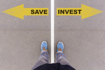Save vs Invest text arrows on asphalt ground, feet and shoes on