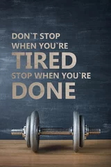 metal barbell on dark gray background and motivation text