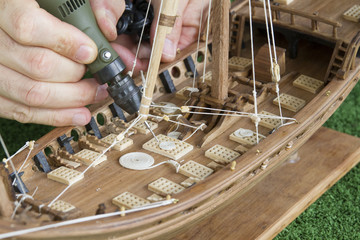 Modéliste travaillant sur une maquette de bateau en bois