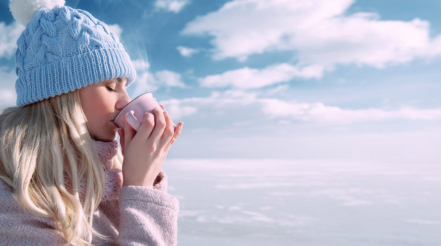 Woman Drinking A Hot Drink In Winter Outdoors